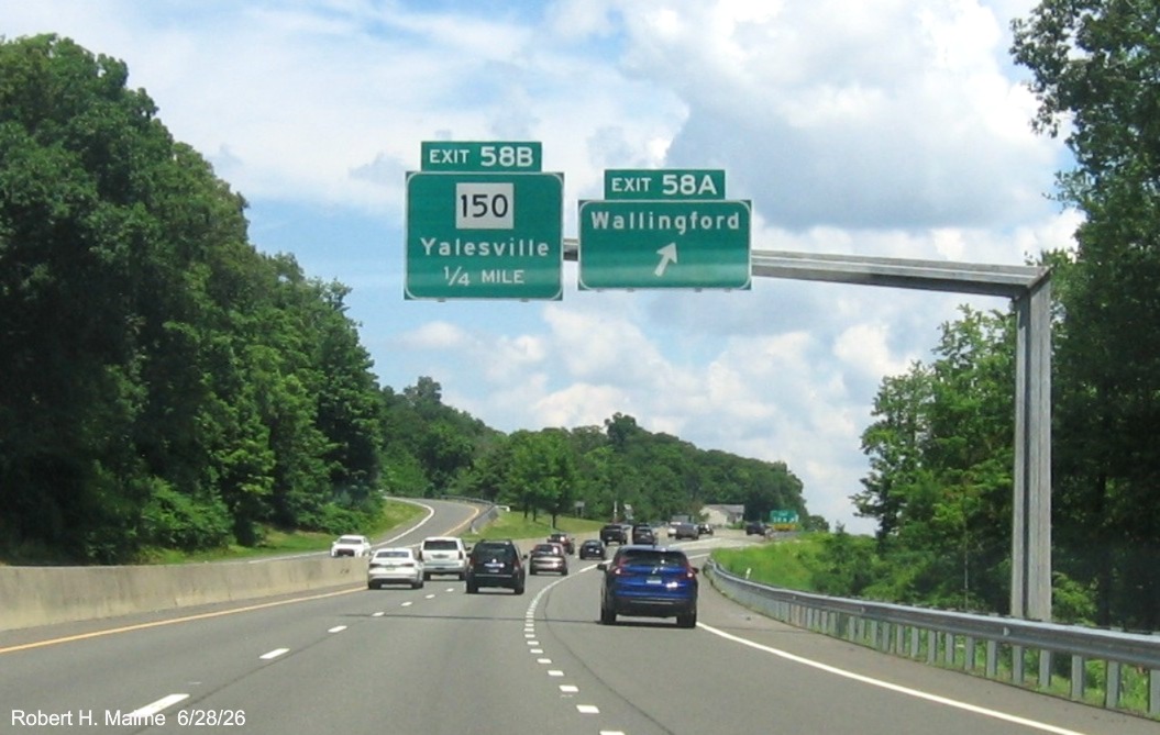 Image of ground mounted advance sign for the Wallingford and CT 150 exits, with
 new milepost based exit number overlays on exit tab on CT 15 North/Cross Parkway in Wallingford, June 2026