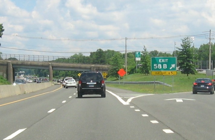 Image of gore sign for the CT 150 exit, with new milepost based exit number overlay 
 on exit tab on CT 15 North/Cross Parkway in Wallingford, June 2026