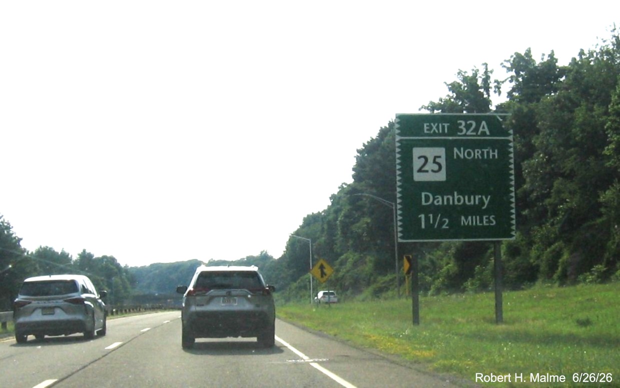 Image of ground mounted 1/2 Mile advance sign for the CT 127 exit, with new milepost 
 based exit number and Old Exit 50 sign on support post on CT 15 South/Merritt Parkway in Trumbull, June 2026