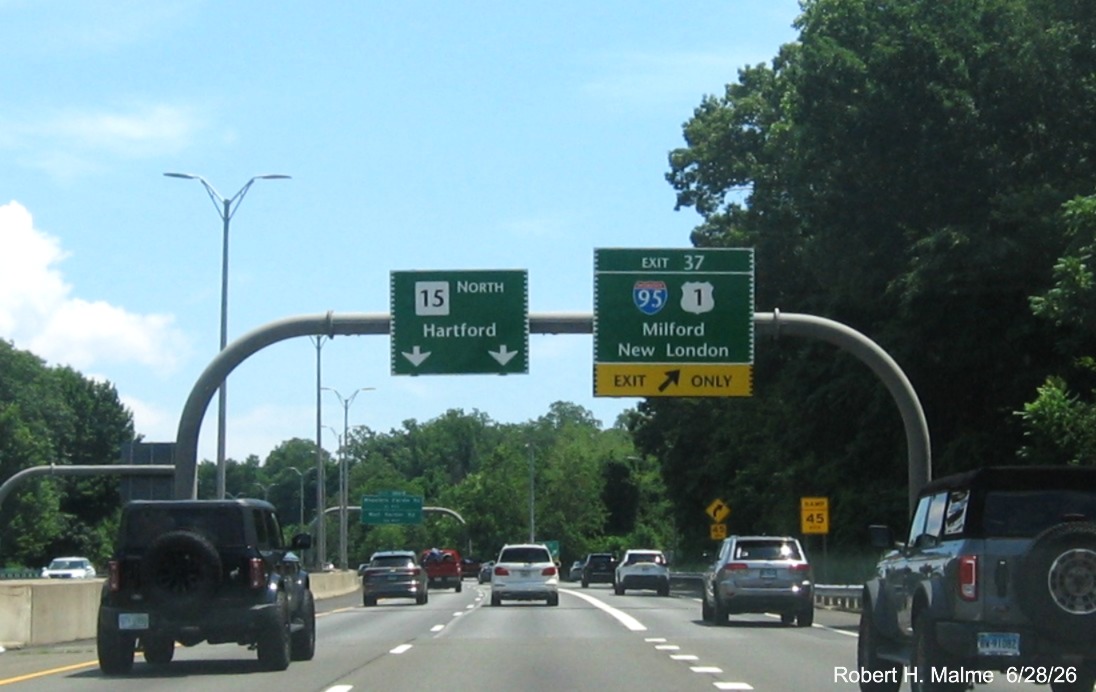 Image of overhead ramp sign for the (To) I-95/US 1 exit, with new milepost 
 based exit number on CT 15 North/Merritt Parkway in Milford, June 2026