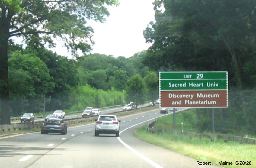 Image of ground mounted green and brown auxiliary sign for the Park avenue exit, with new 
 milepost based exit number on CT 15 North/Merritt Parkway in Fairfield, June 2026