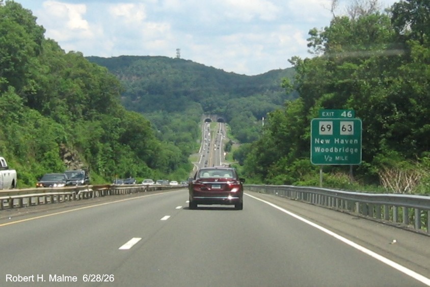Image of ground mounted 1/2 mile advance sign for the CT 69/63 East exit, with new milepost 
 based exit number on CT 15 North/Cross Parkway in Woodbridge, June 2026