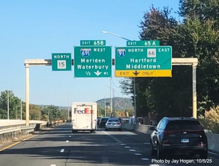 Image of ground mounted exit sign for the East Main Street exit, with
 new milepost based exit number overlay on exit tab on CT 15 North/Cross Parkway in Meriden, by Jay Hogan, August 2025