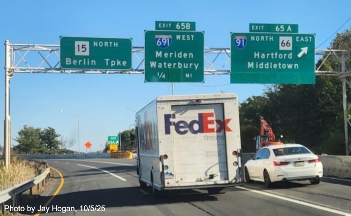 Image of ground mounted exit sign for the East Main Street exit, with
 new milepost based exit number overlay on exit tab on CT 15 North/Cross Parkway in Meriden, by Jay Hogan, August 2025