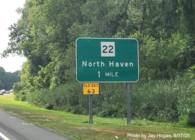 Image of ground mounted 1 Mile advance sign for the CT 22 exit, with no
 new milepost based exit number but a yellow Old Exit 63 sign on support post on CT 15 South/Cross Parkway in North Haven, 
 by Jay Hogan, August 2025