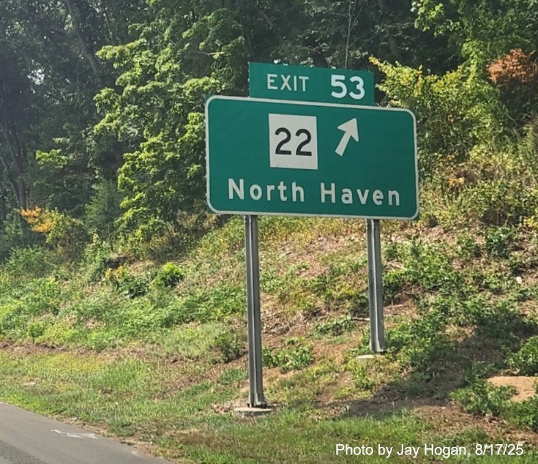 Image of ground mounted ramp sign for CT 22 exit, with new milepost based exit 
 number overlay on exit tab on CT 15 South/Cross Parkway in North Haven, by Jay Hogan, August 2025