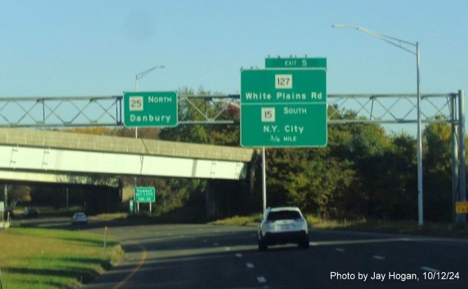 Image of 1/2 mile advance overhead sign with new milepost based exit number and yellow Old Exit 7 A-B sign attached to support post on CT 25 North in Bridgeport, by Jay Hogan, October 2024