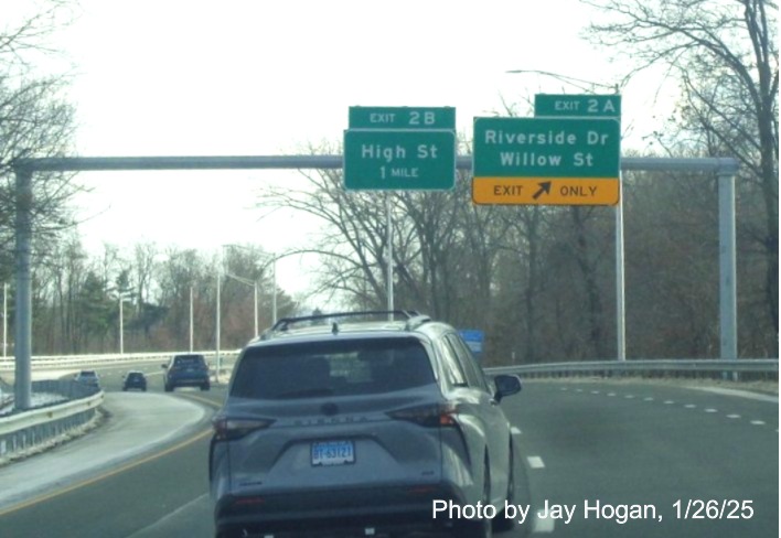 Image of overhead ramp sign for Riverside Drive/Willow Street exit with new milepost 
	  based exit number sharing gantry with advance sign for High Street on CT 2 East in East Hartford, by Jay Hogan, January 2025