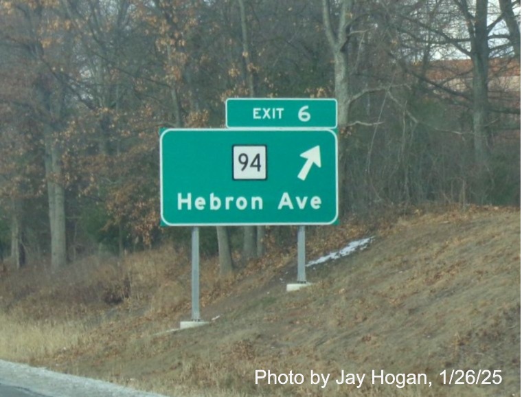 Image of ground mounted ramp sign for CT 94 exit with new milepost based
	  exit number on CT 2 West in Glastonbury, by Jay Hogan, January 2025