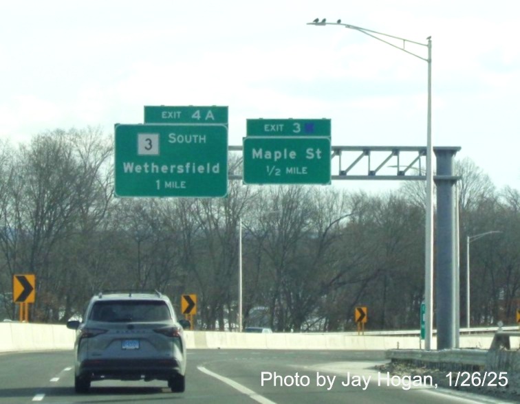 Image of overhead ramp sign for Maple Street exit with new milepost based
	  exit number on CT 2 East in Glastonbury, by Jay Hogan, January 2025