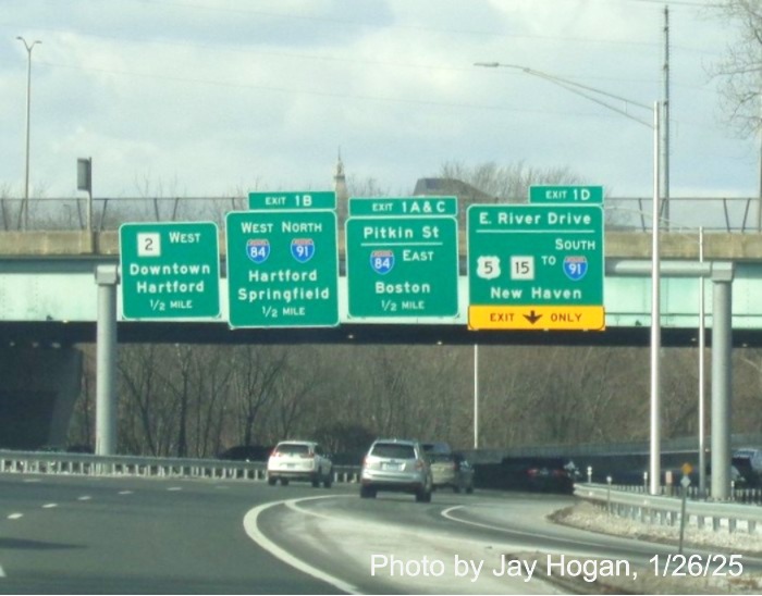 Image of overhead sign with all new Exit 1 signs for I-84, US 5/CT 15 to I-91 South exits on
	  CT 2 West in East Hartford, by Jay Hogan, January 2025