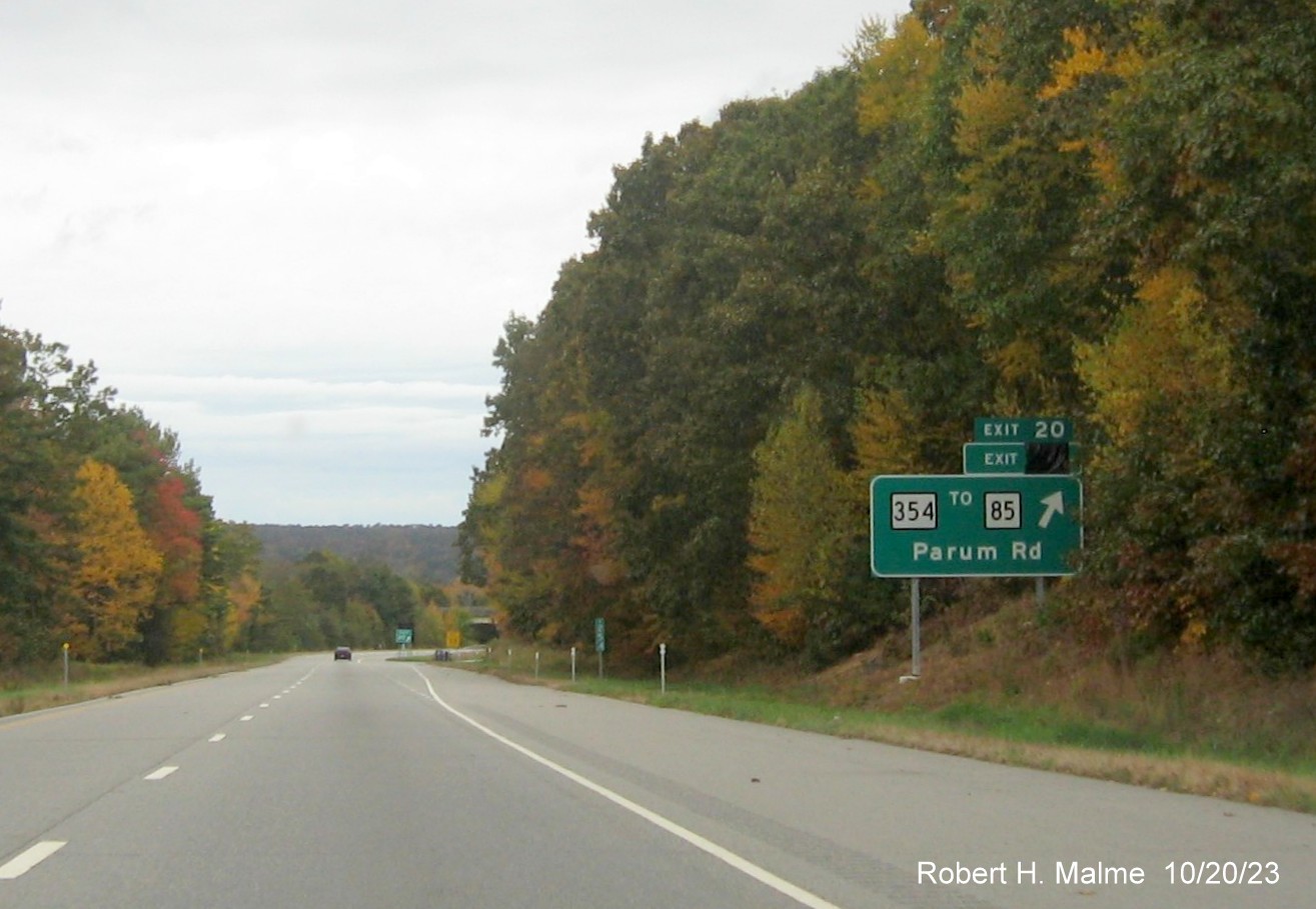 Image of new ground mounted ramp sign for CT 354/Parum Road exit on CT 2 West in Colchester with covered 
      over future exit number (25) and also Old Exit 20 sign, October 2023