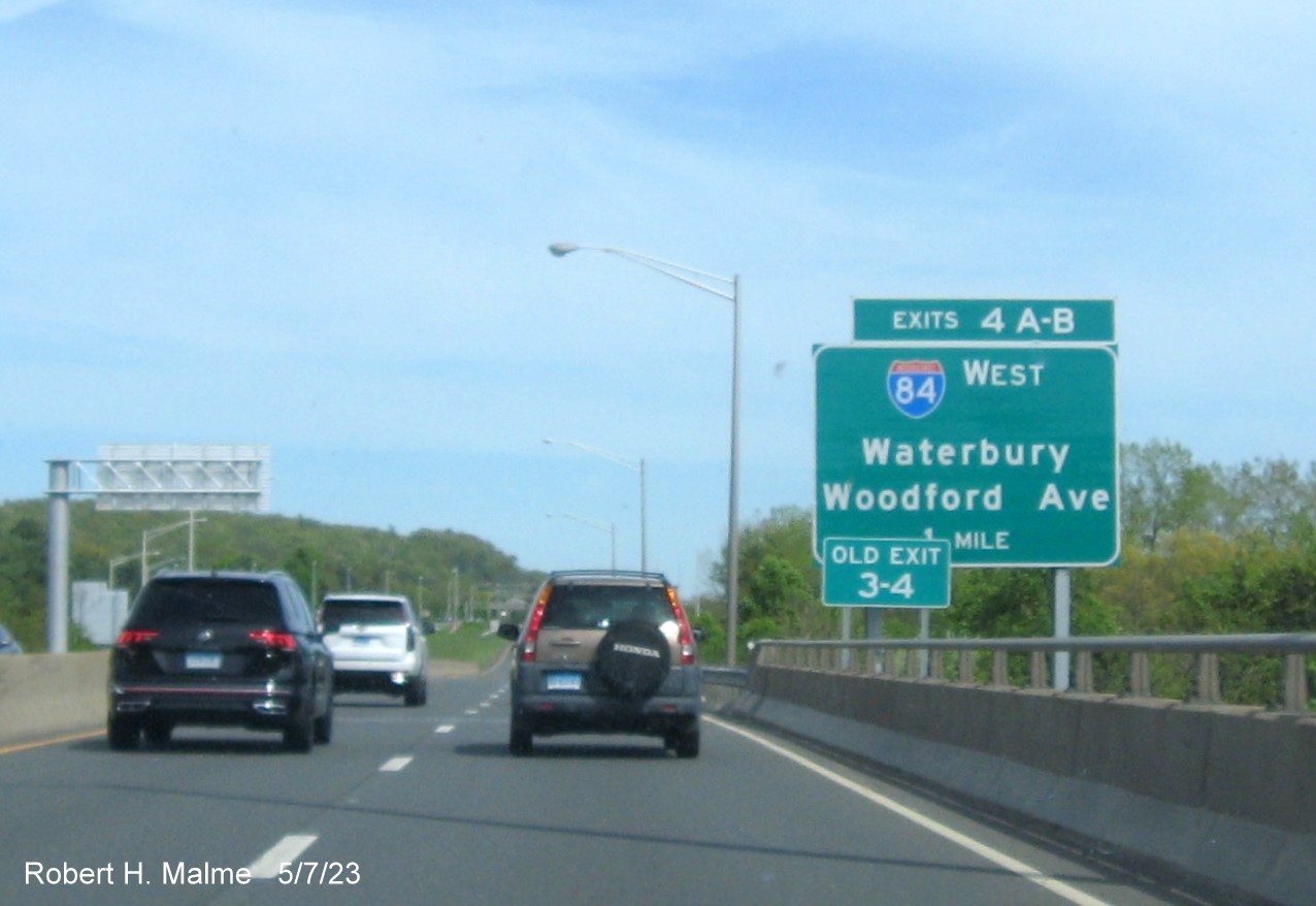 Image of ground mounted 1 mile advance sign for I-84 West/Woodford Avenue exits with new milepost based exit number and Old Exit 3-4 sign below on CT 72 East in Bristol, May 2023