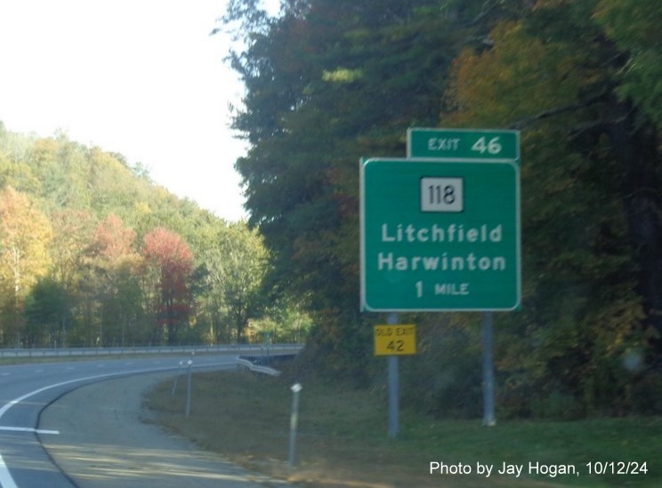 Image of overhead signage for CT 118 exit with new milepost based 
        exit number and attached yellow Old EXIT 42 sign on CT 8 North in Litchfield, by Jay Hogan, October 2024