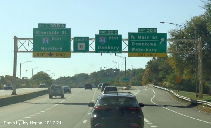 Image of overhead signage for I-84 and Downtown Waterbury exits with new milepost based 
        exit numbers on CT 8 South in Waterbury, by Jay Hogan, October 2024