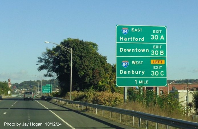 Image of ground mounted auxiliary sign for I-84 and Downtown Waterbury exits with new milepost based 
        exit numbers on CT 8 North in Waterbury, by Jay Hogan, October 2024