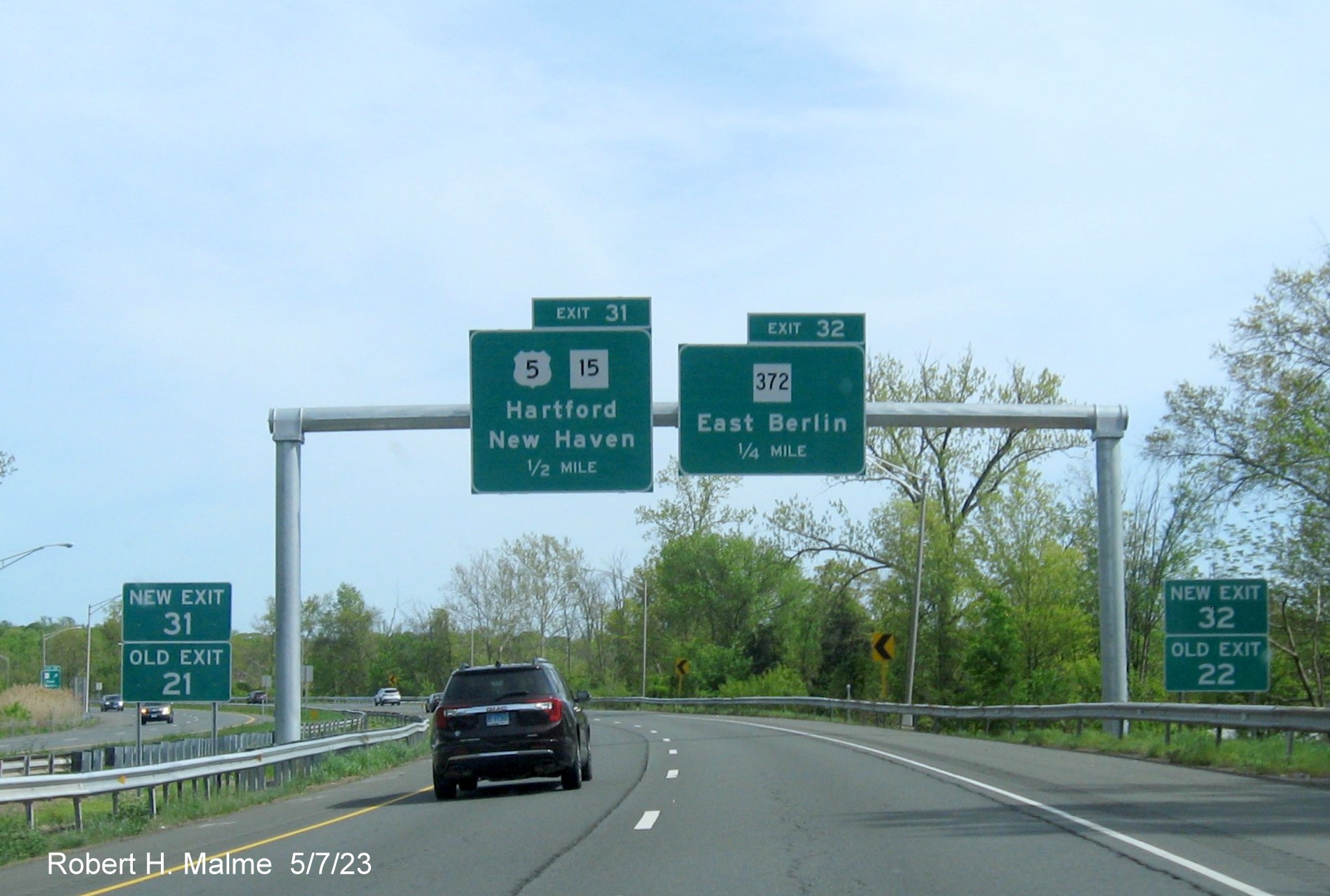Image of 1/2 Mile advance overhead sign US 5/CT 15 and 1/2 mile advance sign for CT 372 exit with new milepost based 
        exit numbers to the left and right on CT 9 South in Berlin, May 2023