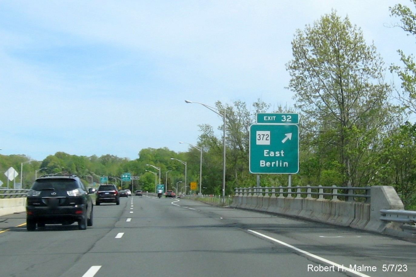 Image of overhead ramp sign for CT 372 exit with new milepost based 
        exit number and Old Exit 22 sign below on CT 9 South in Berlin, May 2023