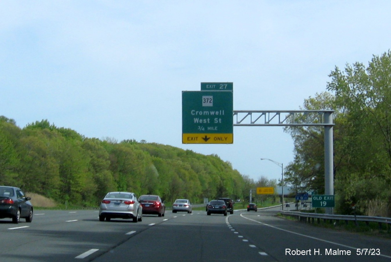 Image of 3/4 mile advance overhead sign for CT 372 exit with new milepost based exit number and separate 
                                     Old Exit 19 sign in front on CT 9 South in Cromwell, May 2023
