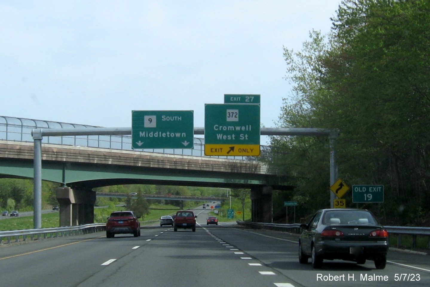 Image of overhead ramp sign for CT 372 exit with new milepost based exit number and separate 
                                     Old Exit 19 sign in front on CT 9 South in Cromwell, May 2023