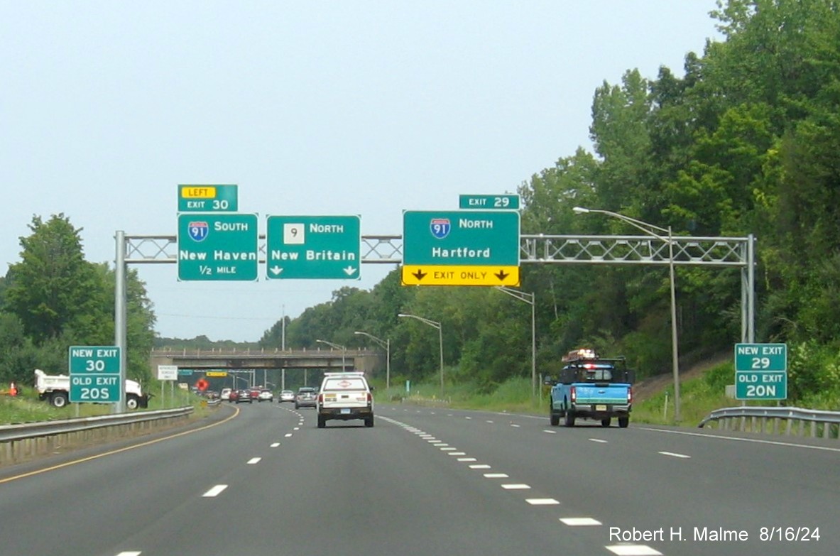 Image of overhead signs for I-91 exits with new milepost based exit number and 
      separate New and Old Exit signs in front on CT 9 North in Cromwell, August 2024