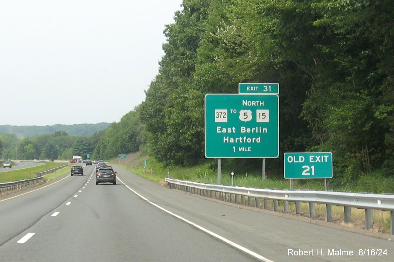 Image of 1 mile advance sign for CT 372 exit with new milepost based exit number and 
      separate Old Exit 21 sign in front on CT 9 North in East Berlin, August 2024