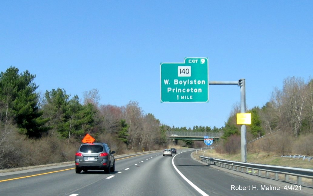 Image of 1 mile advance overhead sign for MA 140 exit with new milepost based exit number and yellow Old Exit 5 advisory sign on support on I-190 North in Princeton, April 2021