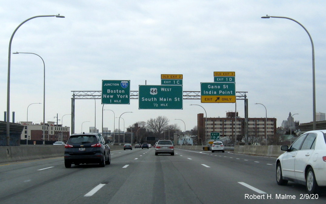 Image of overhead signs for Gano Street and US 44 West with new milepost based exit numbers and old exit number tabs on I-195 West in East Providence