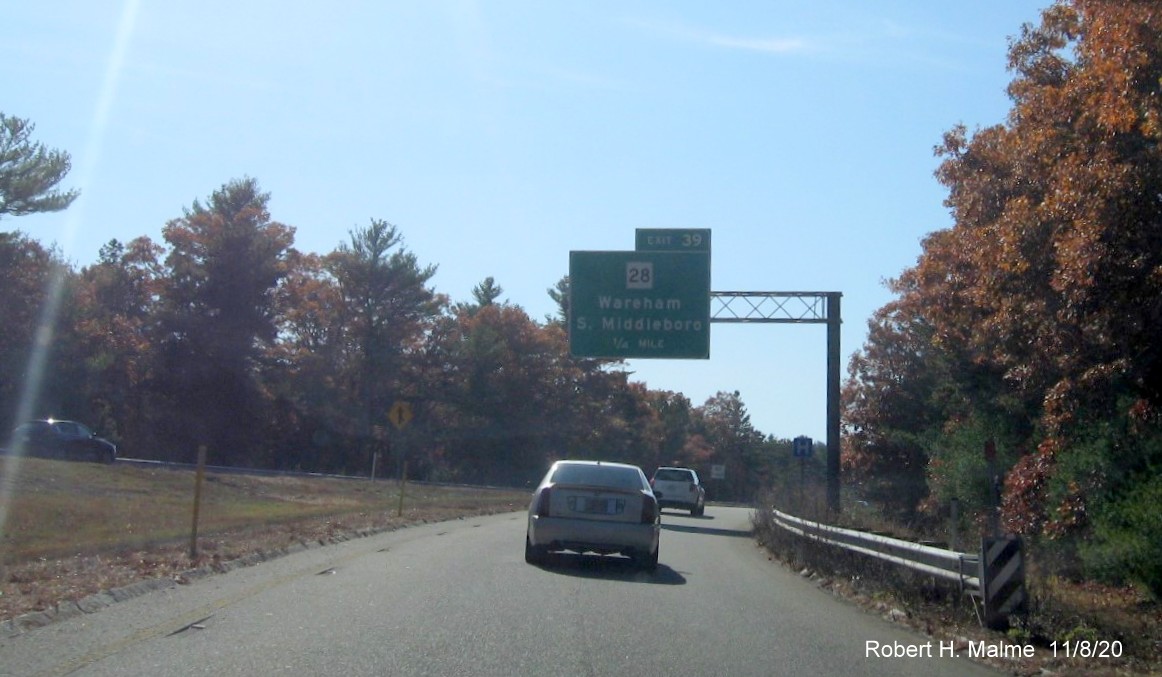 Image of 1/4 mile advance overhead sign for MA 28 exit with new milepost based exit number on ramp from I-495 South to I-195 West in Wareham, November 2020