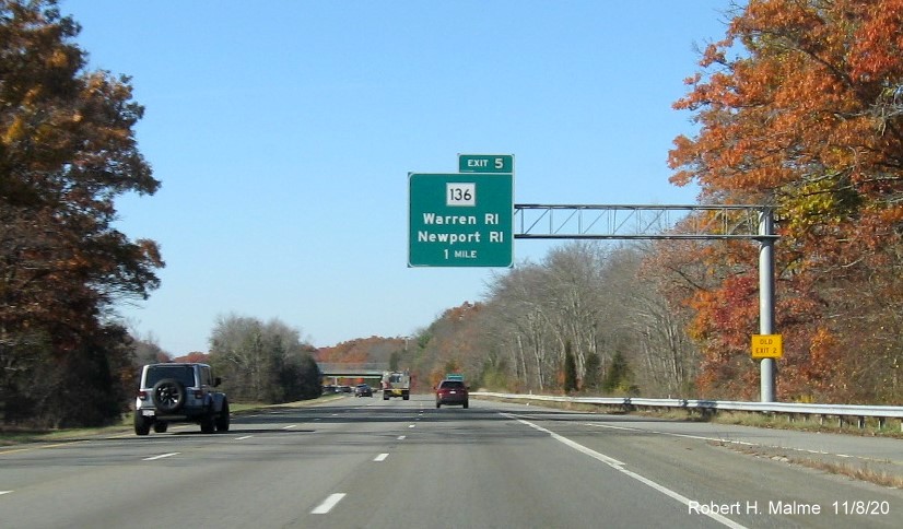 Image of 1 mile advance overhead sign for MA 136 exit with new milepost based exit number and yellow old exit number sign on support post on I-195 West in Swansea, November 2020