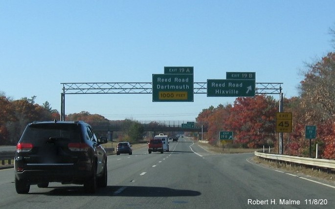 Image of overhead signs at exit ramp to Reed Road North with new milepost based exit numbers and newly numbered gore sign with yellow old exit number tab below on I-195 West in Dartmouth, November 2020