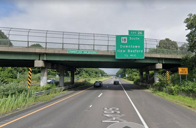 Google Maps Street View image of 1/2 mile advance sign for MA 18 South exit with new milepost based exit number and Old Exit 15 sign on separate supports below bridge on I-195 East in New Bedford, July 2021