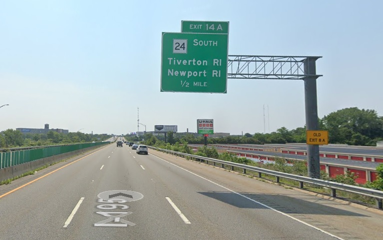 Google Maps Street View image of 1/2 mile advance overhead sign for MA 24 South exit with new milepost based exit number and yellow Old Exit 8A advisory sign on support on I-195 East in Fall River, July 2021