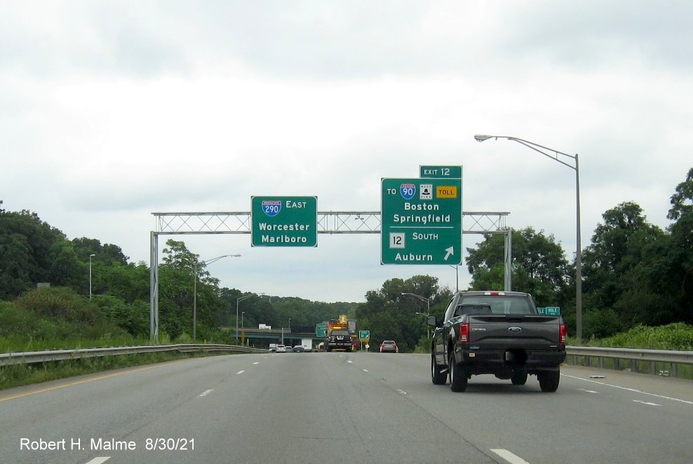 Image of overhead ramp sign for I-90/Massachusetts Turnpike and MA 12 exit with new milepost based exit number and yellow Old Exit 7 advisory sign on right support on I-395 North in Auburn, August 2021