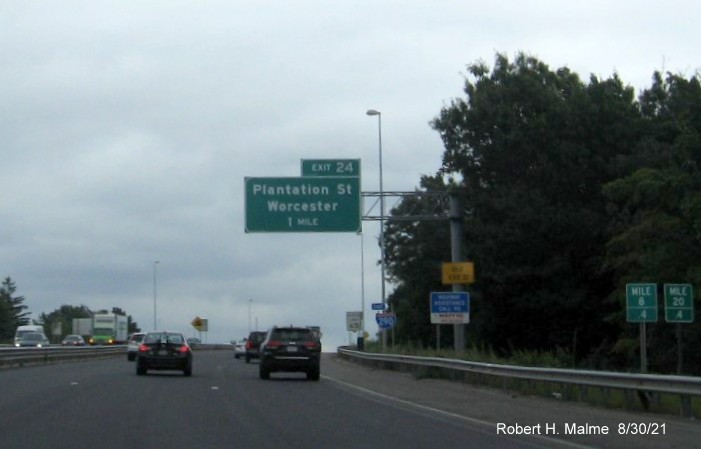 Image of 1 mile advance overhead sign for Plantation Street exit with new I-395 milepost based exit number and yellow Old Exit 21 advisory sign on support on I-290 East in Worcester, August 2021