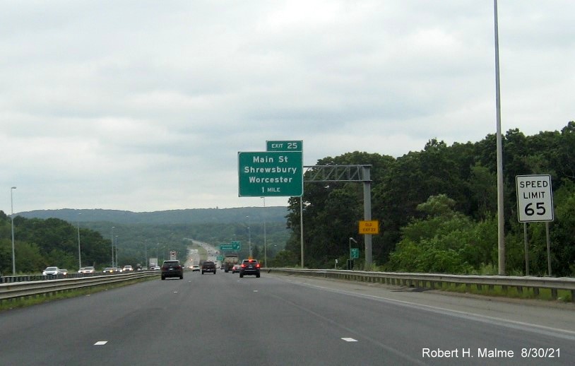 Image of 1 mile advance overhead sign for Main Street exit with new I-395 milepost based exit number and yellow Old Exit 22 advisory sign on support on I-290 East in Worcester, August 2021