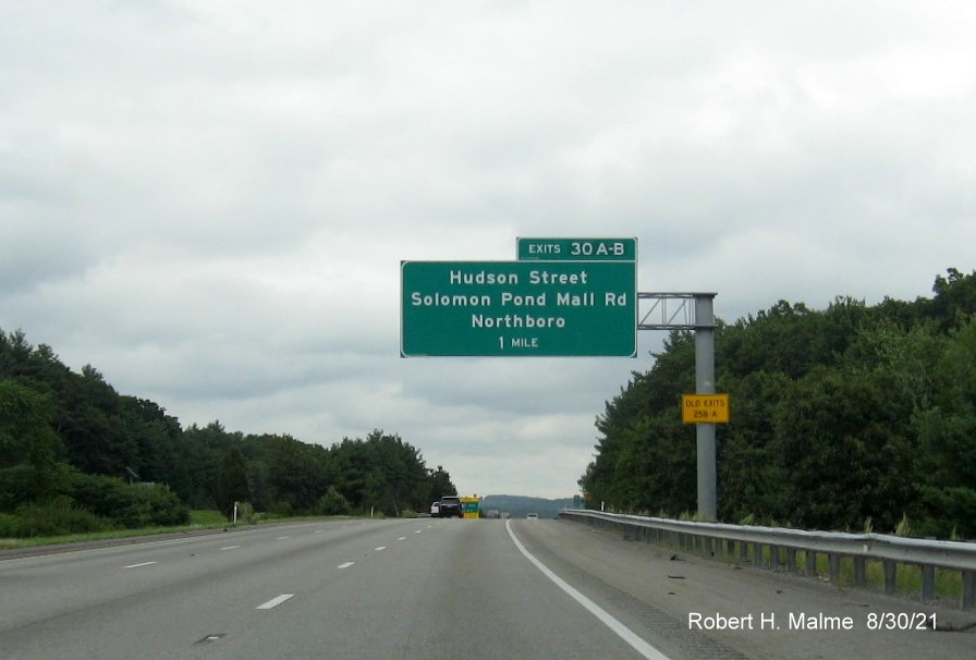 Image of 1 mile advance overhead sign for Hudson Street/Solomon Pond Mall Road exit with new milepost based exit number and yellow Old Exits 25 A-B advisory sign on support on I-290 East in Boylston, August 2021