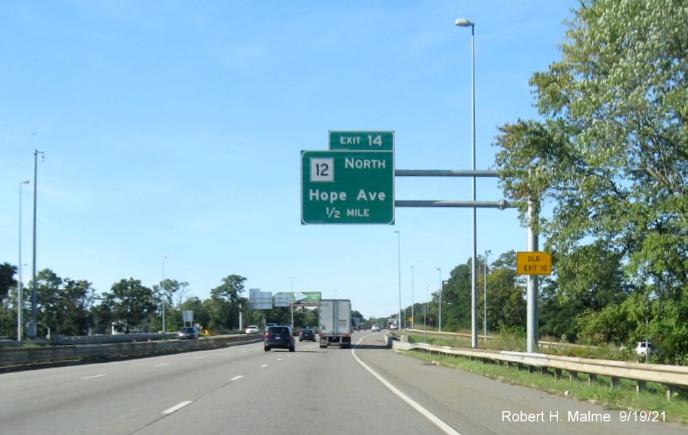 Image of new 1/2 mile advance overhead sign for MA 12 North eixt with new milepost based exit number and (duplicate) yellow Old Exit 10 advisory sign on support on I-290 West in Worcester, September 2021