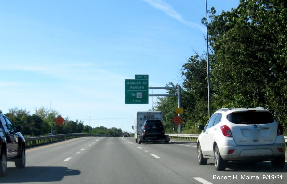 Image of 1 mile advance overhead sign for Auburn Street exit with new milepost based exit number and yellow Old Exit 9 advisory sign on support on I-290 West in Auburn, September 2021