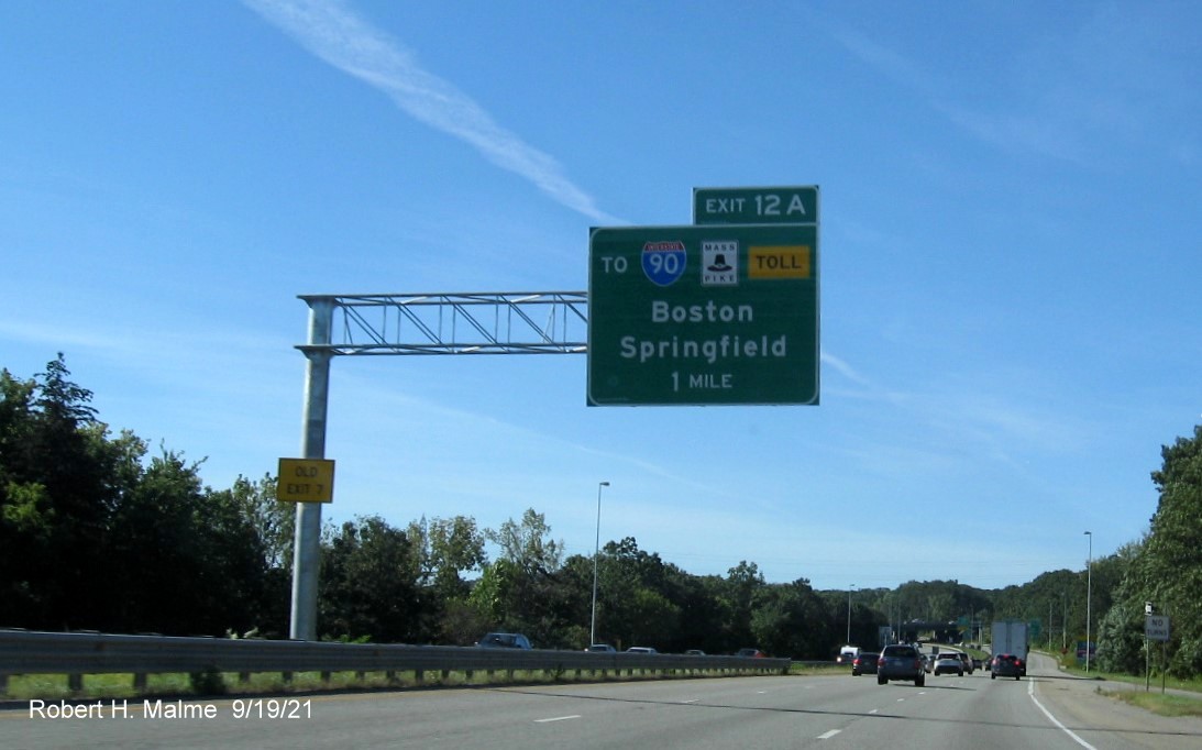 Image of newly placed left side 1 mile advance overhead sign for To I-90/Mass Pike exit with new milepost based exit number and yellow Old Exit 7 advisory sign on I-290 West in Auburn, September 2021