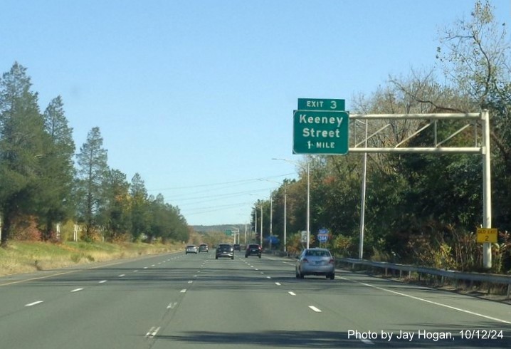 Image of 1 mile advance overhead sign for Keeney Street exit with new milepost based exit number 
      and yellow Old Exit 2 sign on support post, by Jay Hogan, October 2024