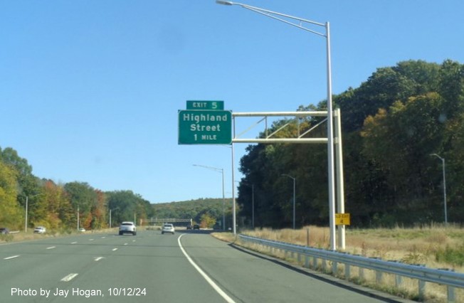 Image of 1 mile advance overhead sign for Highland Street exit with new milepost based ext number 
      and yellow Old Exit 4 sign on support post, by Jay Hogan, October 2024