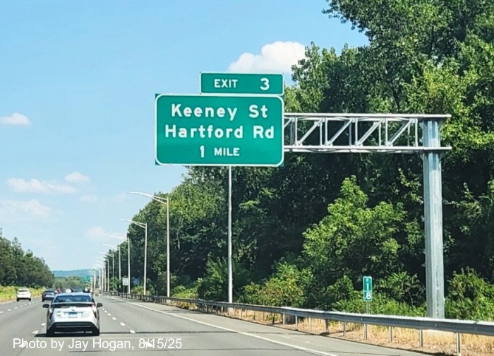 Image of new 1 mile advance overhead sign for the Keeney Street/Hartford Road
	exit with milepost based exit number, by Jay Hogan, August 2025