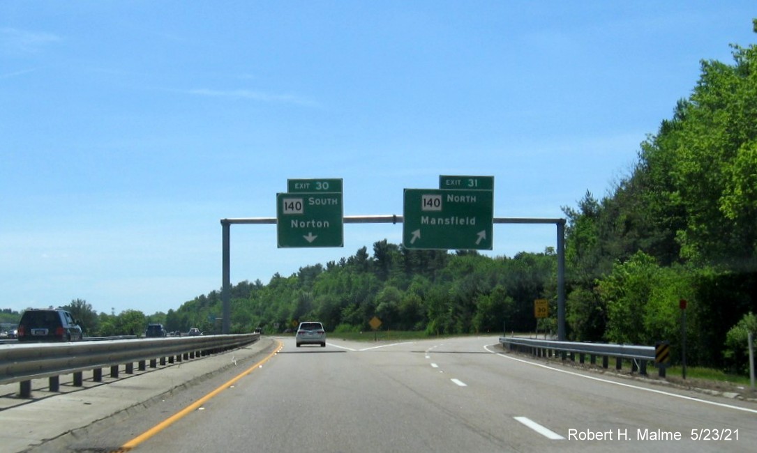 Image of 1 mile advance overhead sign for MA 140 exits with new milepost based exit numbers and yellow Old Exits 12-11 advisory sign on support on I-495 South in Mansfield, May 2021