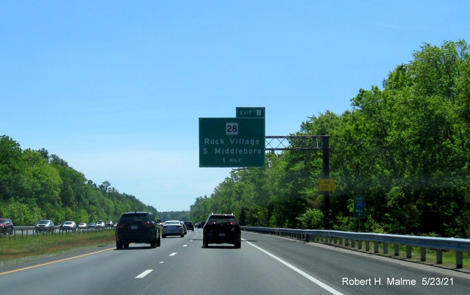 Image of 1 mile advance overhead sign for MA 28 exit with new milepost based exit number and yellow Old Exit 3 
                                       advisory sign on support on I-495 South in Middleboro, May 2021
