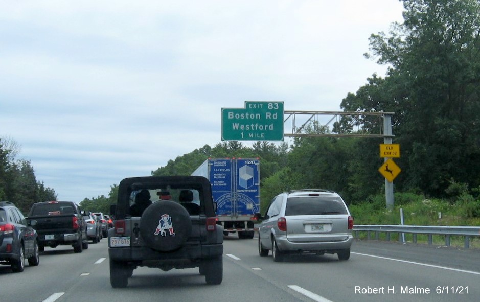 Image of 1 mile advance overhead sign for Boston Road exit with new milepost based exit number and yellow Old Exit 32 advisory sign on support on I-495 North in Westford, June 2021