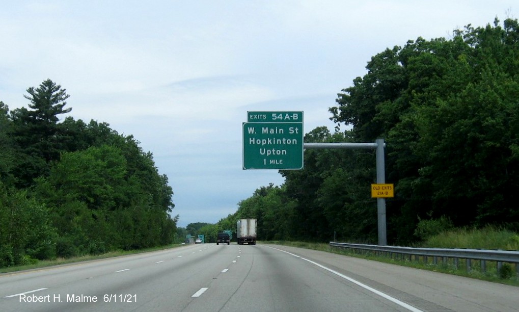 Image of 1 mile advance overhead sign for West Main Street exits with new milepost based exit numbers and yellow Old Exits 20 A-B advisory sign on support on I-495 North in Hopkinton, June 2021