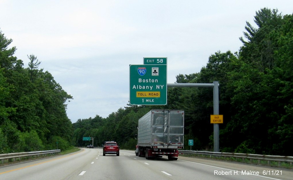 Image of 1 mile advance overhead sign for I-90/Massachusetts Turnpike exit with new milepost based exit number and yellow Old Exit 22 advisory sign on support on I-495 North in Hopkinton, June 2021