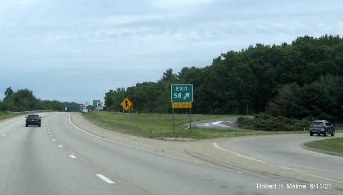Image of gore sign for I-90/Massachusetts Turnpike exit with new milepost based exit number and yellow Old Exit 22 sign attached below on I-495 North in Hopkinton, June 2021