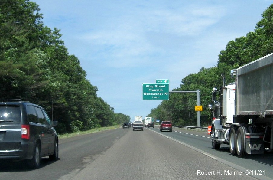 Image of 1 mile advance overhead sign for King Street exit with new milepost based exit number and yellow Old Exit 16 advisory sign on support on I-495 North in Franklin, June 2021